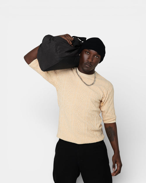 Pransh The Jacq-ed Tee in Beige, men’s 3D jacquard knit premium cotton t-shirt with all-over Pransh logo texture, front view styled on model