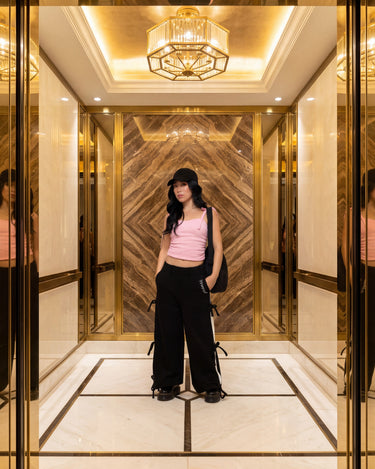 Pransh Sanctuary Collection, model in Pransh's premium Halo wide leg French terry sweatpants with bow straps, styled in luxe gold interior