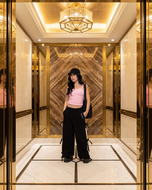 Pransh Sanctuary Collection, model in Pransh's premium Halo wide leg French terry sweatpants with bow straps, styled in luxe gold interior