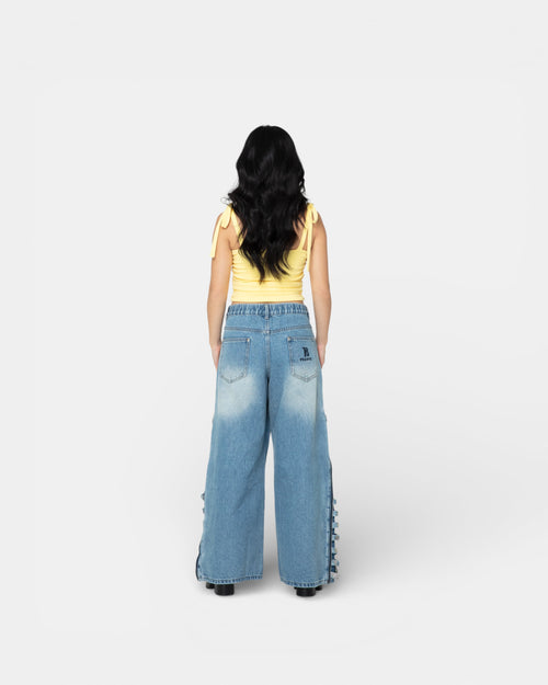 Back view of Pransh Muse Cinch Top in Honey, women’s cropped stretch jersey top with adjustable tie straps, styled on model